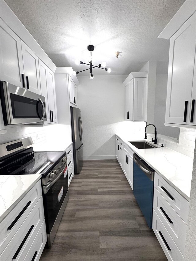 7147 Yacht Basin Ave Unit 119, Orlando, FL 32835 - kitchen with baseboards, a sink, a chandelier, stainless steel appliances, and tasteful backsplash