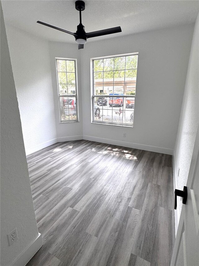 7147 Yacht Basin Ave Unit 119, Orlando, FL 32835 - empty room featuring baseboards, ceiling fan, a textured wall, and wood finished floors