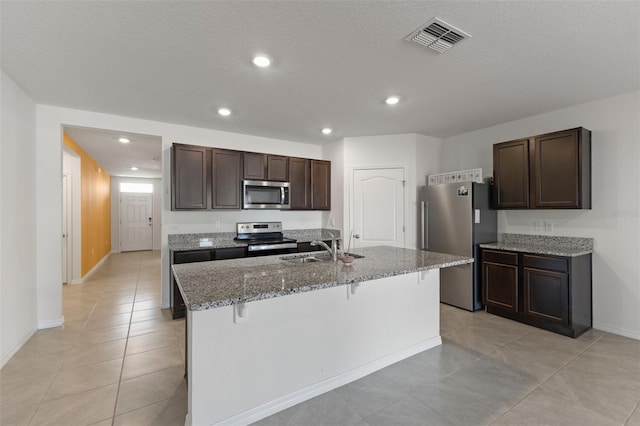 kitchen featuring a sink, baseboards, dark brown cabinetry, and stainless steel appliances