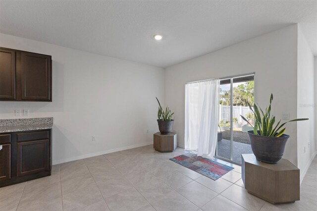 interior space featuring baseboards, recessed lighting, and light tile patterned floors