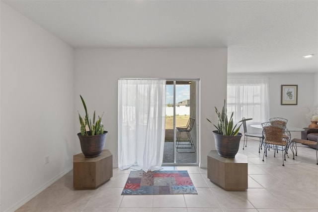 doorway to outside featuring baseboards and light tile patterned floors