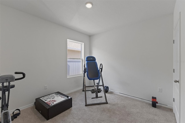 workout room featuring baseboards and carpet