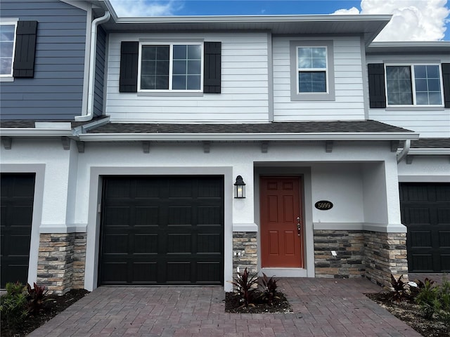 5099 Prairie Preserve Run, Saint Cloud, FL 34772 - view of front of property with stone siding, an attached garage, and stucco siding