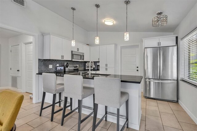 440 E Crystal Lake St, Orlando, FL 32806 - kitchen with stainless steel appliances, dark countertops, visible vents, and a kitchen breakfast bar