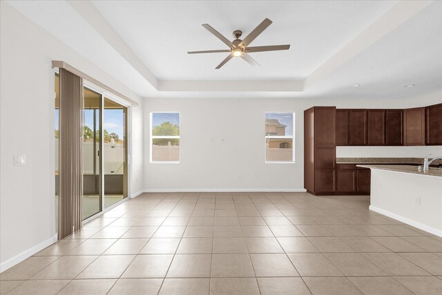 16780 Meadows St, Clermont, FL 34714 - kitchen with a tray ceiling, a ceiling fan, and baseboards