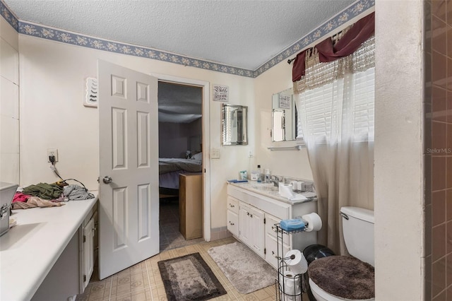ensuite bathroom with vanity, toilet, connected bathroom, and a textured ceiling