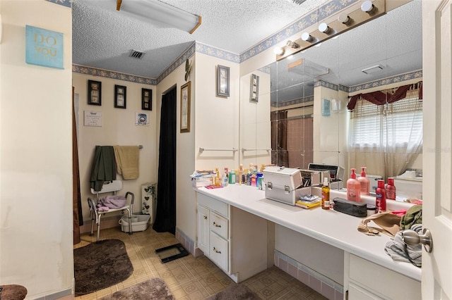 bathroom featuring a shower with curtain, tile patterned floors, a textured ceiling, visible vents, and vanity