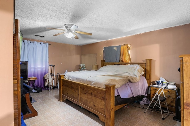 bedroom featuring a textured ceiling, visible vents, and ceiling fan
