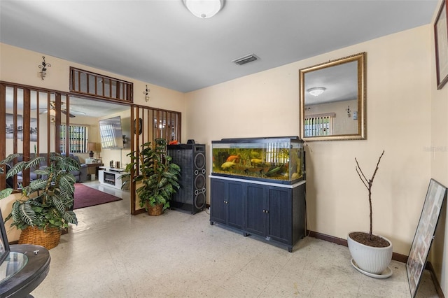 living area featuring light floors, visible vents, and baseboards