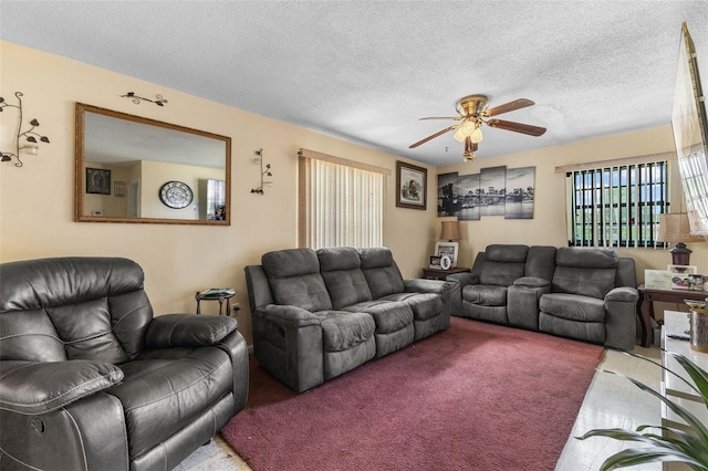 carpeted living area featuring a textured ceiling and ceiling fan