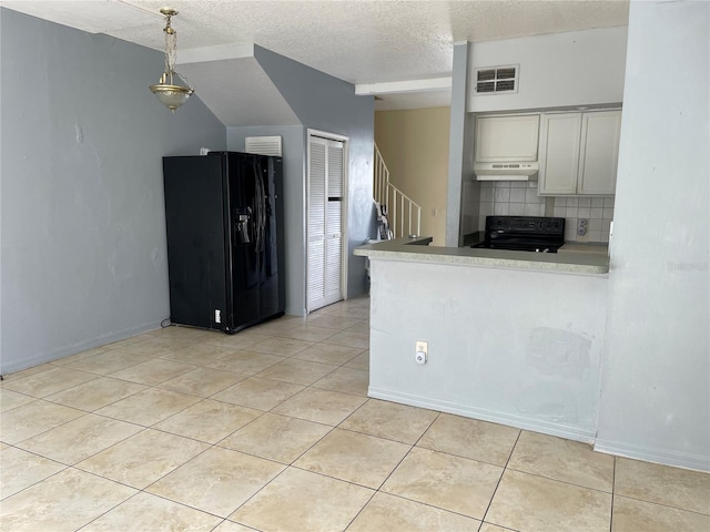 kitchen featuring visible vents, light tile patterned flooring, under cabinet range hood, backsplash, and black appliances