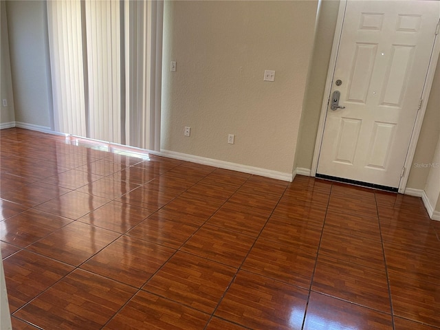 empty room featuring baseboards and tile patterned floors