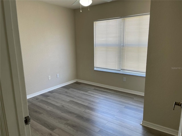 unfurnished room with baseboards, a ceiling fan, and wood finished floors