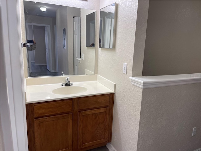 bathroom featuring a textured wall and vanity