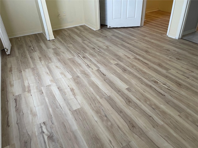 unfurnished bedroom with baseboards and light wood-style flooring