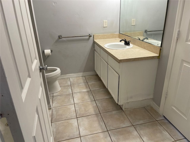bathroom with toilet, tile patterned floors, baseboards, and vanity