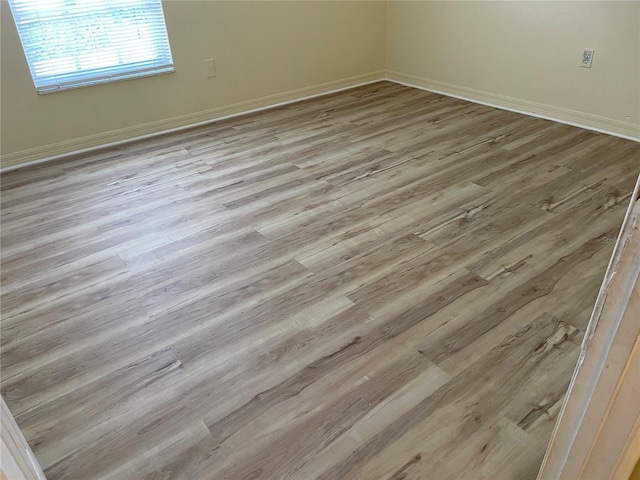 empty room with baseboards and wood finished floors