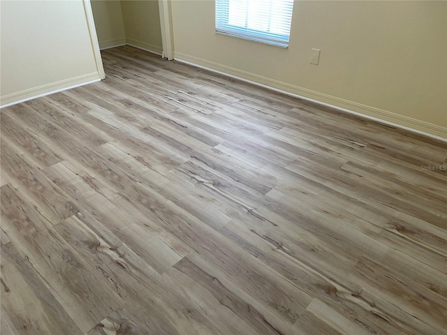interior space featuring baseboards, a closet, and light wood finished floors
