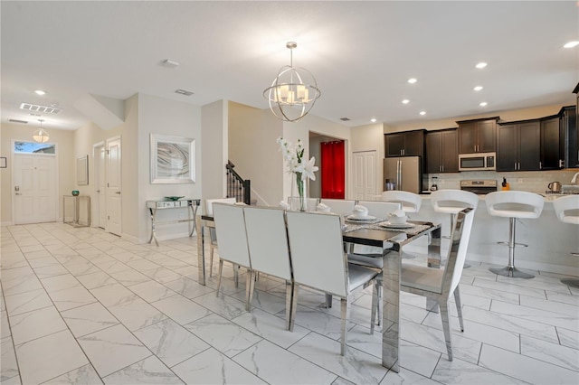 9034 Stinger Dr, Davenport, FL 33896 - dining room featuring visible vents, recessed lighting, marble finish floor, and a notable chandelier