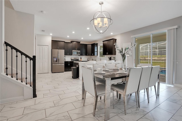 9034 Stinger Dr, Davenport, FL 33896 - dining area with an inviting chandelier, recessed lighting, marble finish floor, and stairway