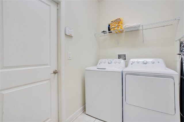 9034 Stinger Dr, Davenport, FL 33896 - laundry room with separate washer and dryer, baseboards, and laundry area