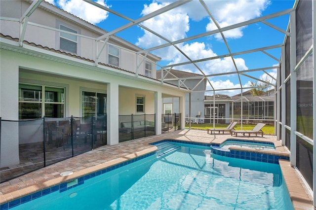 9034 Stinger Dr, Davenport, FL 33896 - view of pool featuring glass enclosure, a pool with connected hot tub, and a patio area