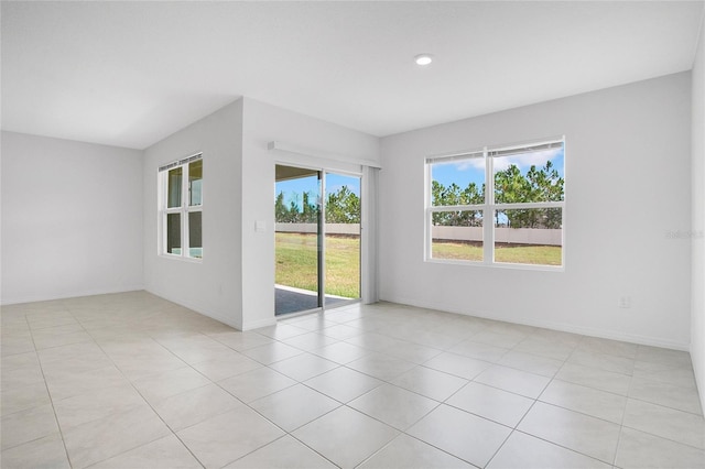 empty room featuring light tile patterned floors, baseboards, and recessed lighting