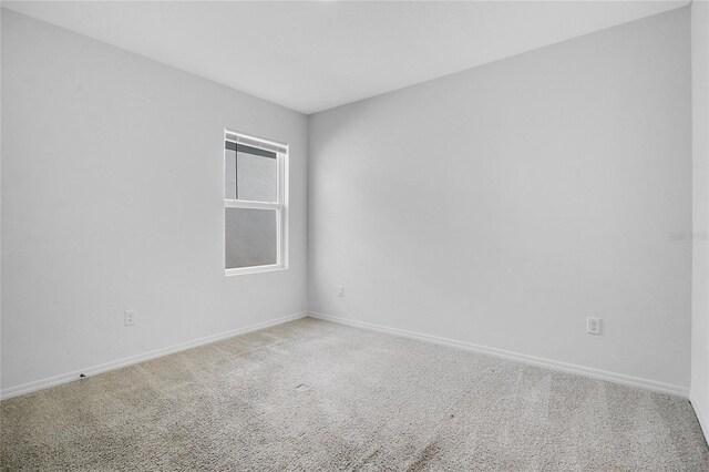 empty room featuring baseboards and carpet