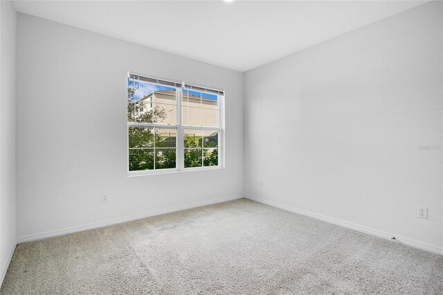 carpeted empty room with baseboards
