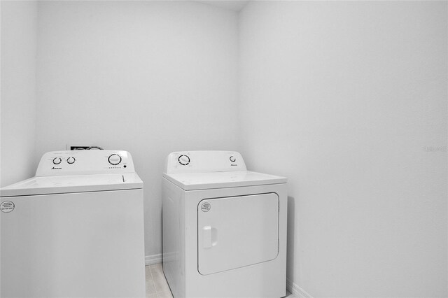 clothes washing area featuring baseboards, laundry area, and washer and clothes dryer