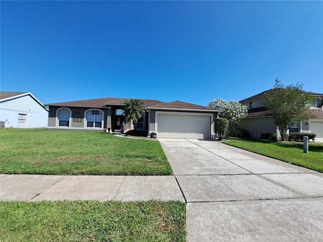 single story home with a garage, driveway, a front yard, and stucco siding