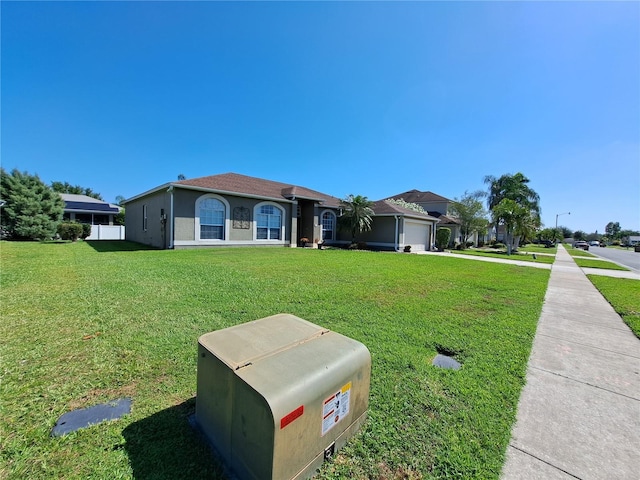 view of front of home with fence, a garage, stucco siding, a front yard, and concrete driveway