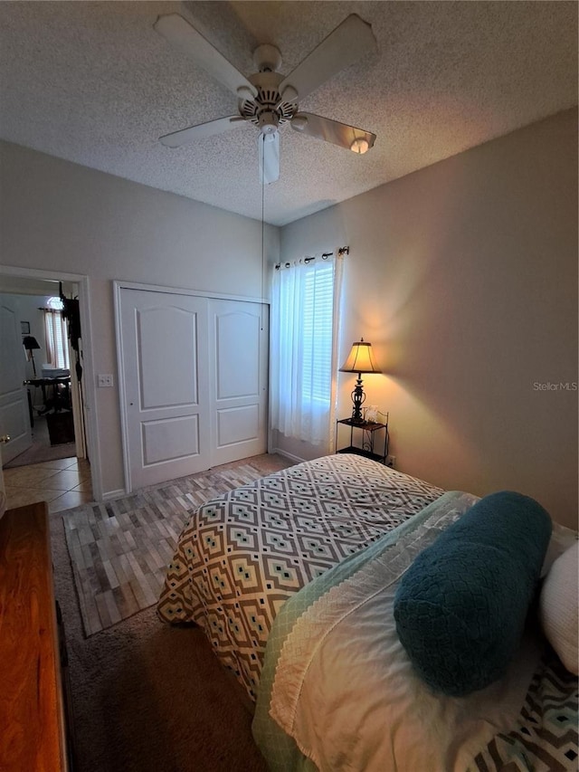 bedroom featuring a closet, a textured ceiling, and ceiling fan
