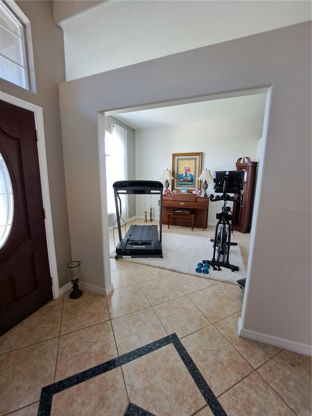 tiled entryway featuring baseboards and plenty of natural light