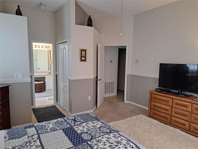 carpeted bedroom with visible vents, connected bathroom, baseboards, and high vaulted ceiling