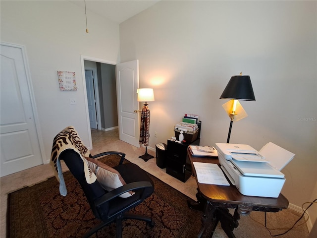home office with baseboards and light colored carpet