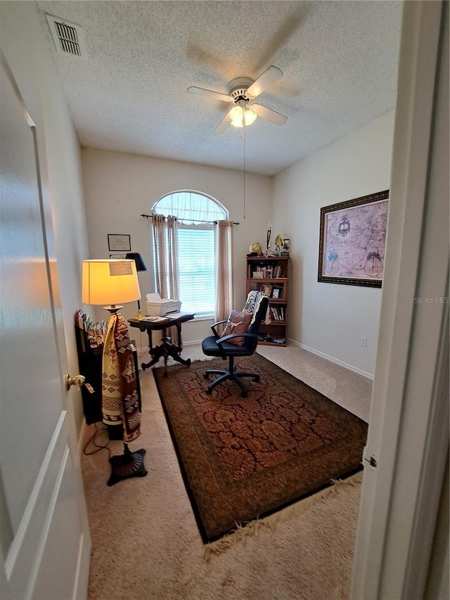 office space with carpet floors, a ceiling fan, a textured ceiling, and visible vents