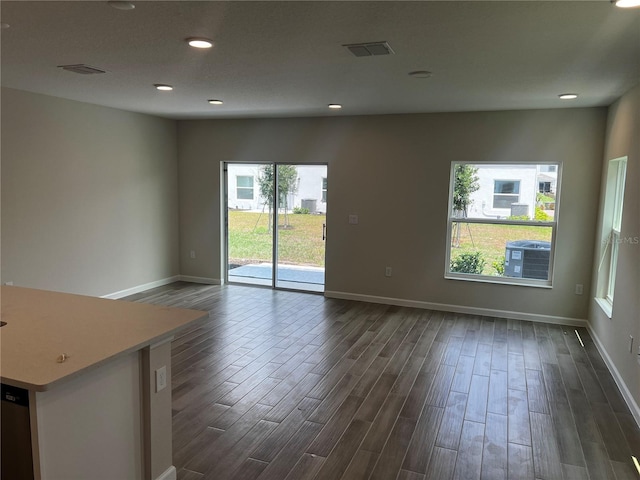 empty room with dark wood-style floors, baseboards, and recessed lighting