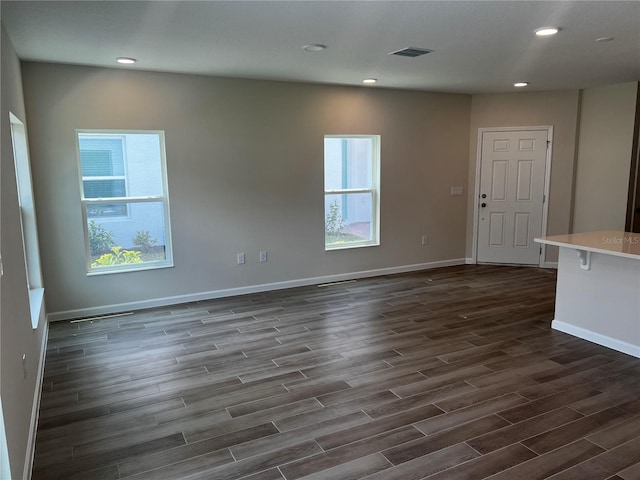 unfurnished room with dark wood-type flooring, plenty of natural light, baseboards, and recessed lighting