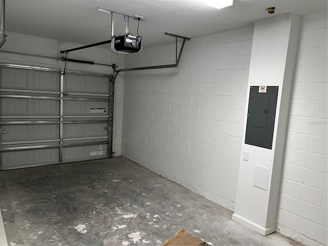 garage featuring a garage door opener, concrete block wall, and electric panel