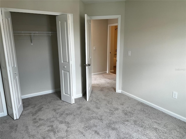 unfurnished bedroom with carpet flooring, a closet, and baseboards