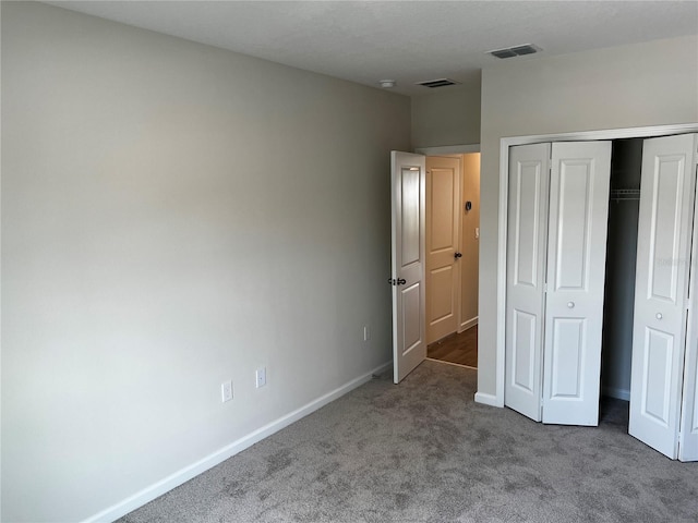 unfurnished bedroom with carpet flooring, a closet, and baseboards