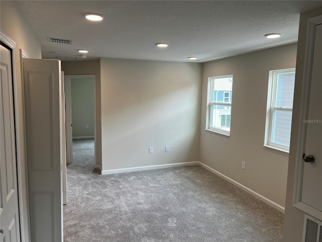 empty room featuring carpet floors, recessed lighting, and baseboards