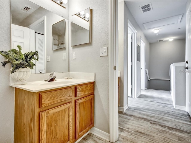4560 Spigold Ct, Kissimmee, FL 34746 - bathroom featuring wood finished floors, a textured wall, vanity, and baseboards