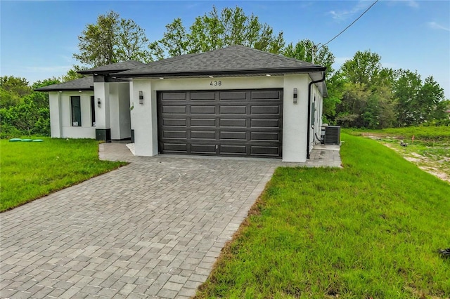 view of front facade featuring stucco siding, an attached garage, decorative driveway, and a front yard