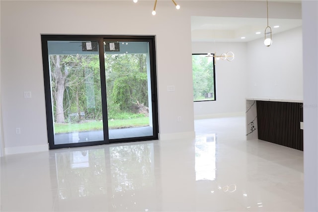 empty room with tile patterned floors and a chandelier