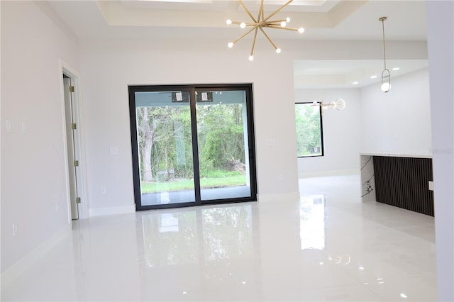 tiled spare room featuring a notable chandelier and a raised ceiling