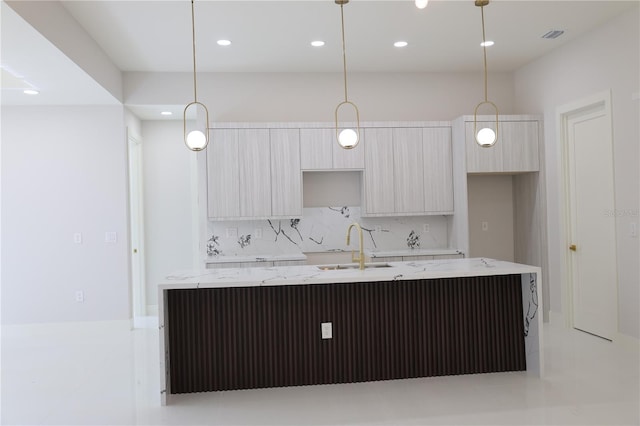 kitchen with a kitchen island with sink, modern cabinets, recessed lighting, tasteful backsplash, and a sink