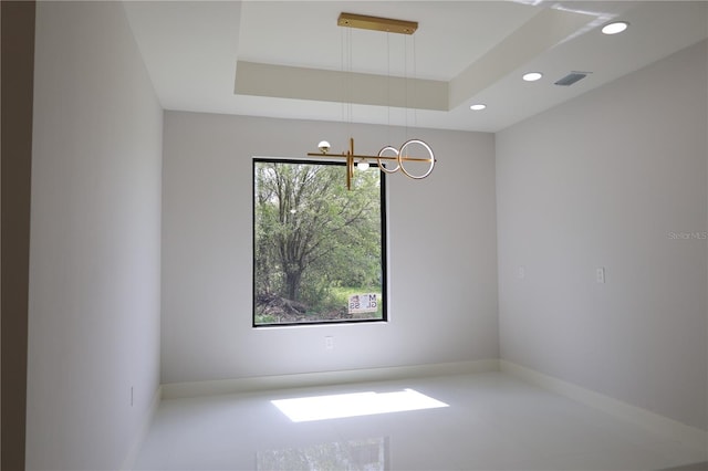 spare room with visible vents, baseboards, recessed lighting, a raised ceiling, and a notable chandelier