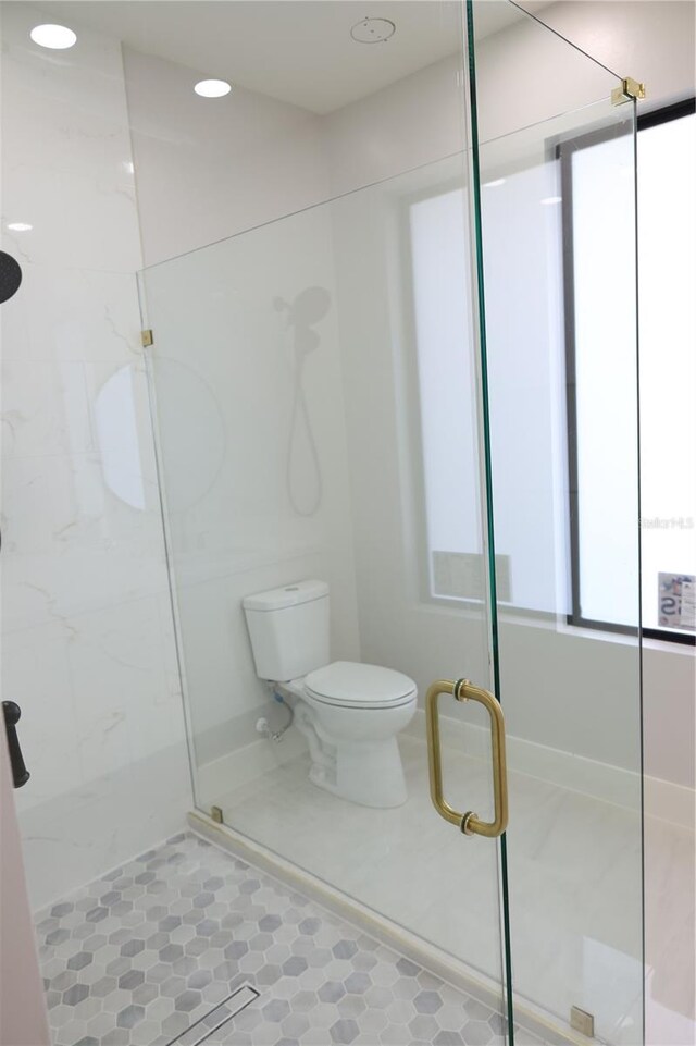 bathroom featuring a marble finish shower, tile patterned flooring, and toilet